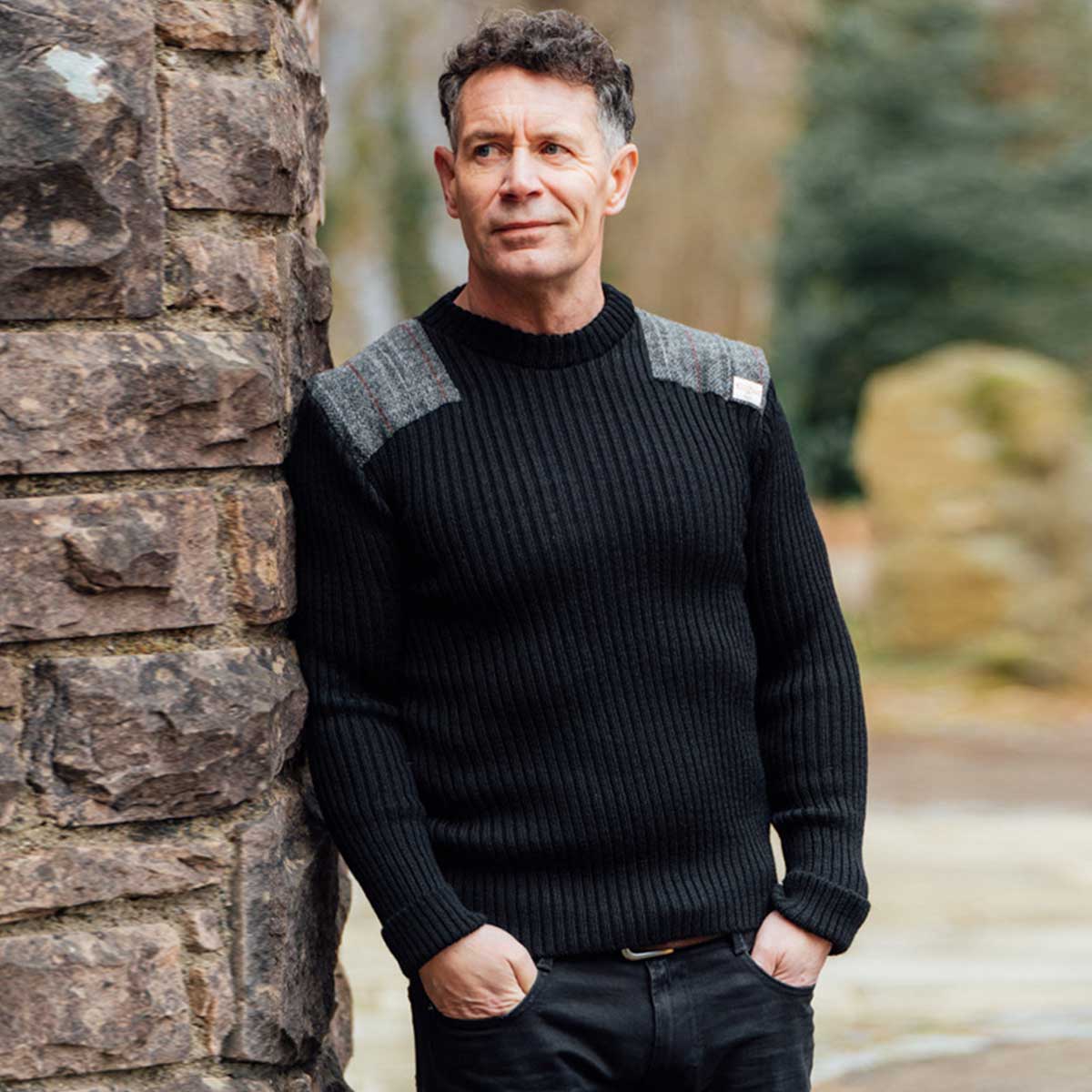 model wearing forrester crew neck woolly pully sweater with harris tweed patches black