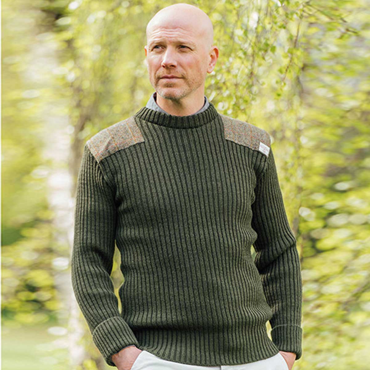 model wearing forrester crew neck woolly pully sweater with harris tweed patches olive